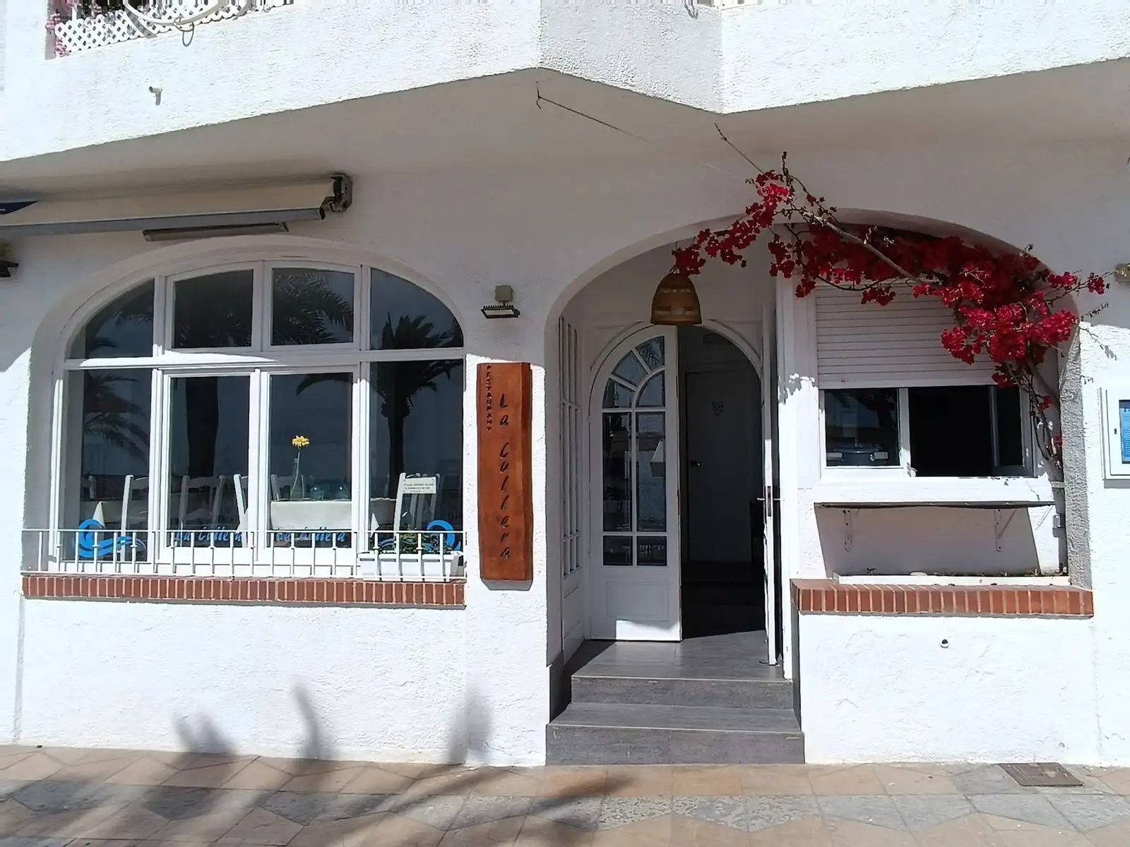 Fachada del restaurante La Cullera del Poal en el paseo marítimo de Vinaròs, destacando su entrada acogedora y ubicación frente al mar.
